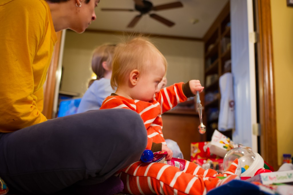 Atticus admires how his 'Baby's First Christmas' spoon catches the light as he dangles it around